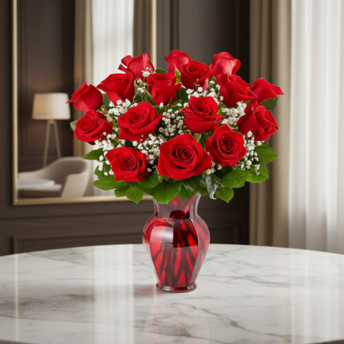 Jarrón Amor Incondicional con un hermoso arreglo de rosas rojas frescas y follaje verde, sobre una mesa de mármol en un elega